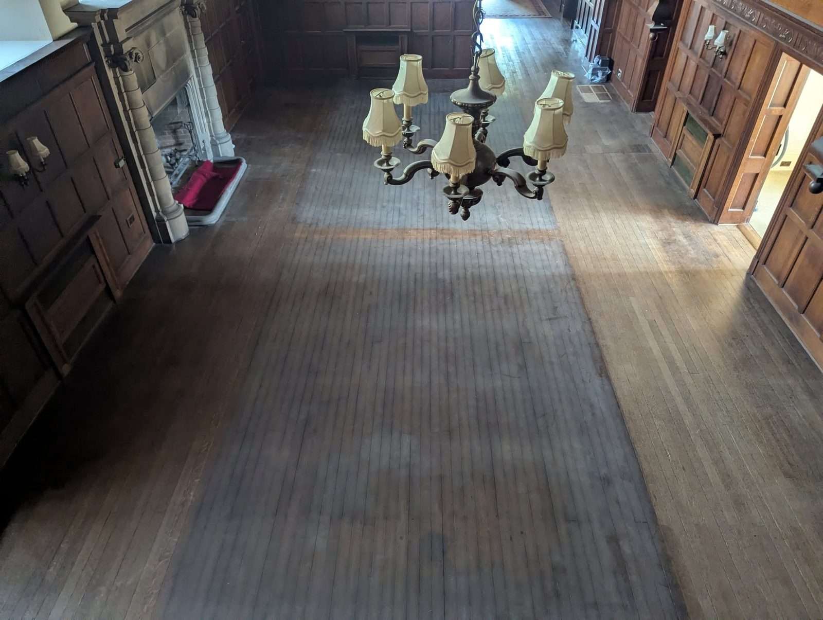 Old English oak floor at Higham Hall before sanding, with a dark worn finish and patchy colour